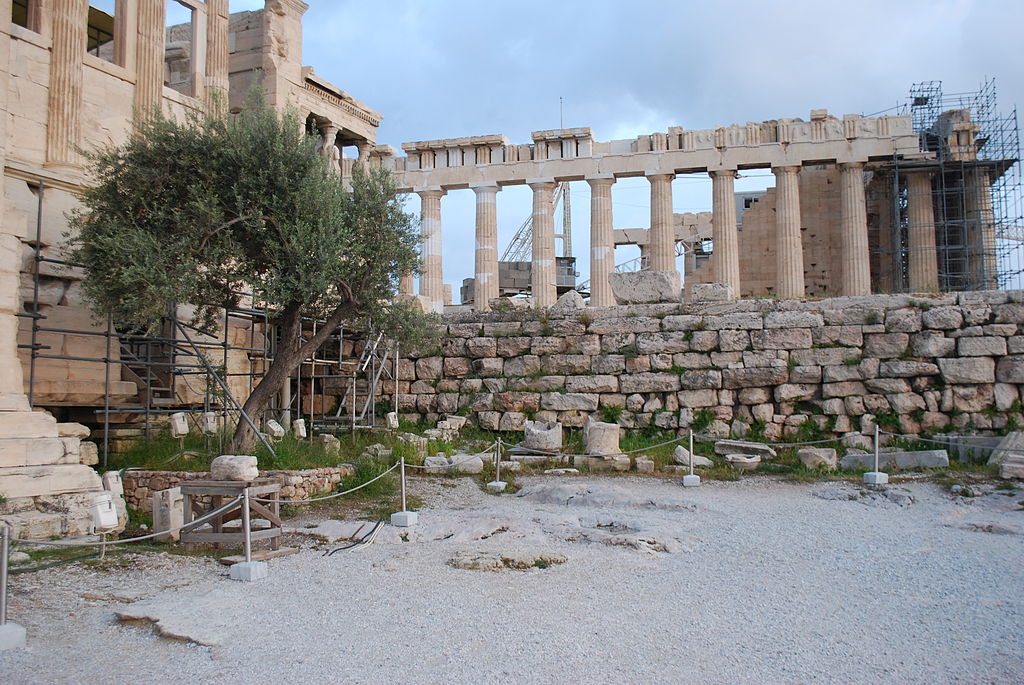 Místo po Pandroseionu (Pandrosionu) vedle Erechtheionu (vlevo). V pozadí o patro výše je Parthenón. Kredit: Jean Housen, Wikimedia Commons. Licence CC 3.0.