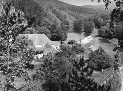 Skryjský mlýn a říční údolí roku 1967. Pohled z vyhlídky nad skálou skoro naproti mlýnu, tedy z mohelenské strany. Lokalita Plevovce se skrývá v zatáčce u levého horního okraje snímku. Kredit: Zde, Wikimedia Commons. Licence CC 4.0.